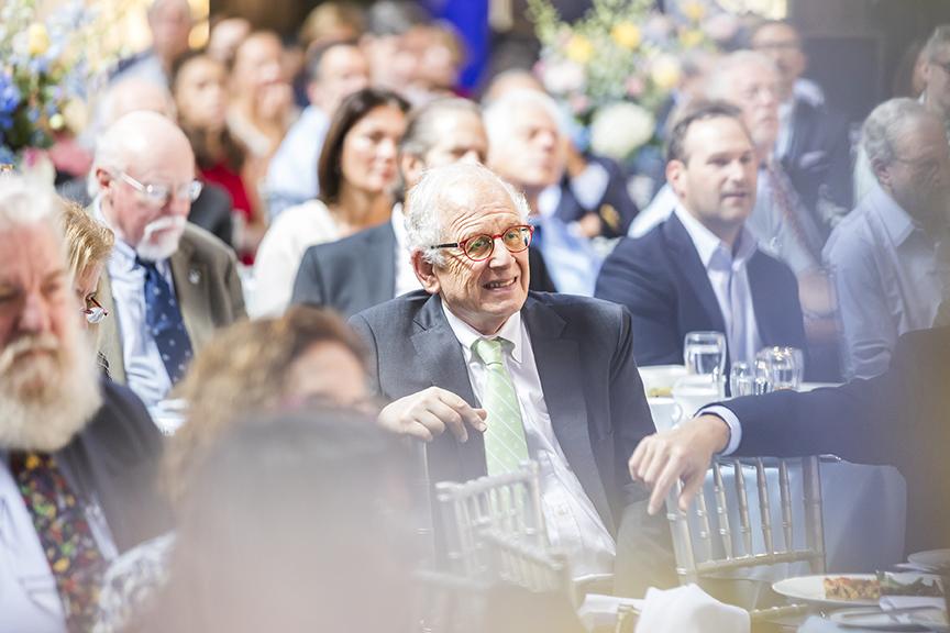 Guests enjoying the program seated at round tables.