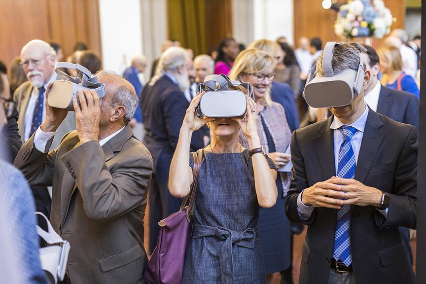 Guests of the Opening Event exploring the Virtual Reality googles as part of the student exhibit.