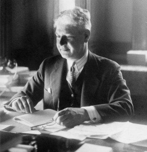 Professor John J. Coss sitting at his desk.